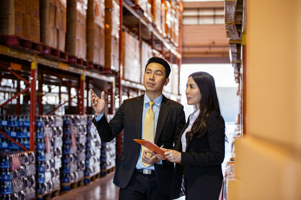 Asian two business people discussing of product at storage warehouse