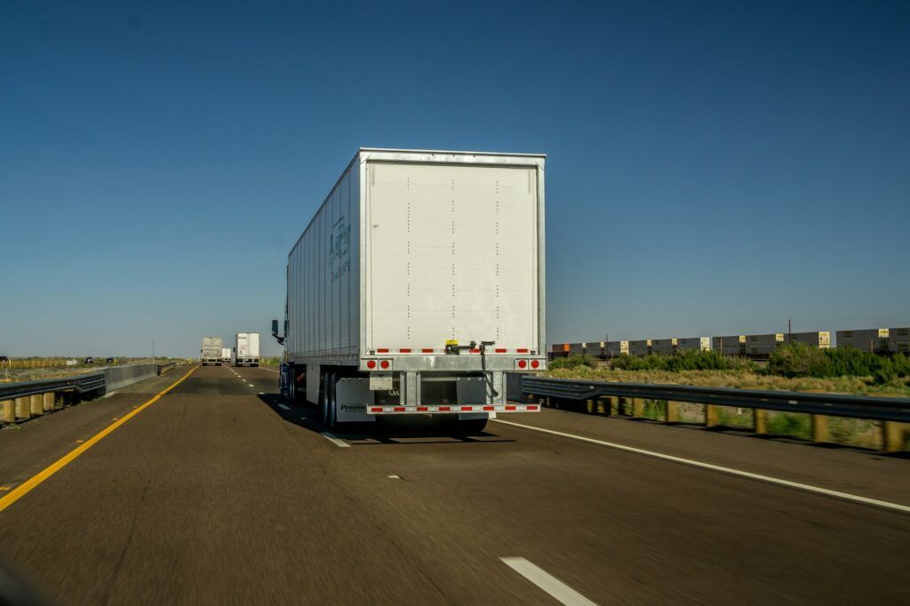 View from behind of tractor trailer trucks driving on an interstate highway